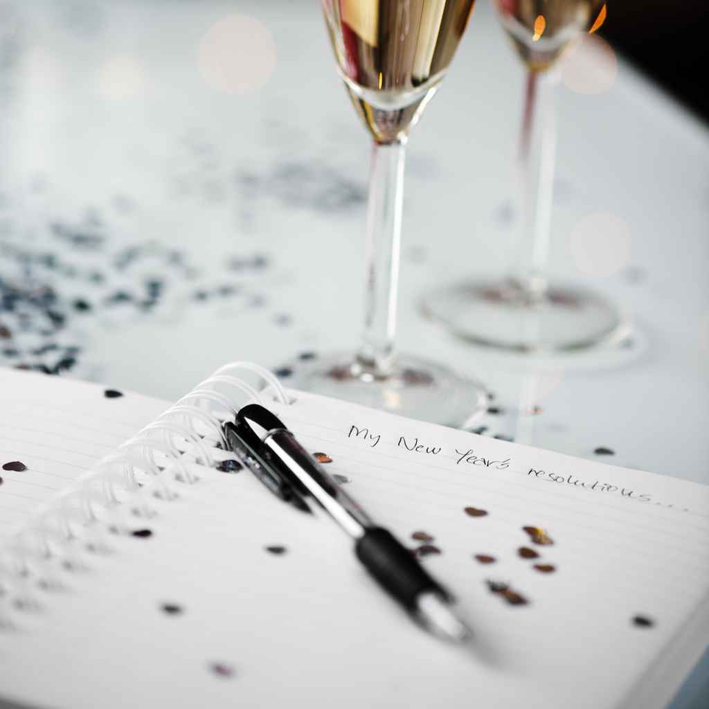 Celebration still life - Champagne, notepad with pen, and confetti on a table