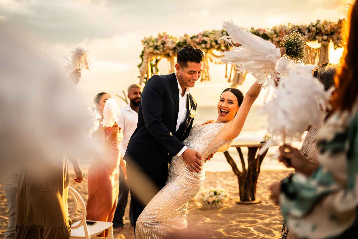 Newlyweds celebrating with their guests at beach wedding ceremony