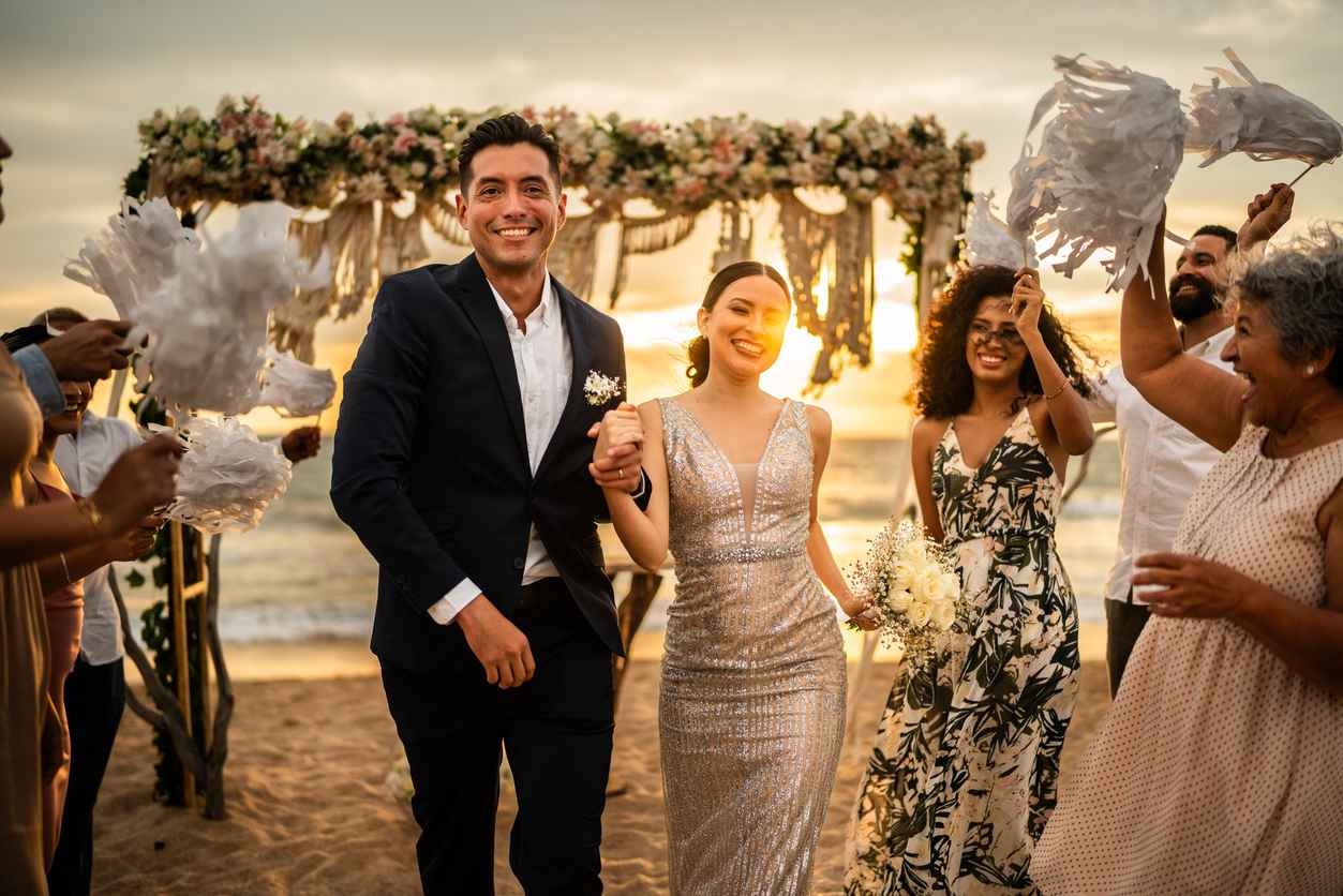 Newlyweds celebrating with their guests at beach wedding ceremony