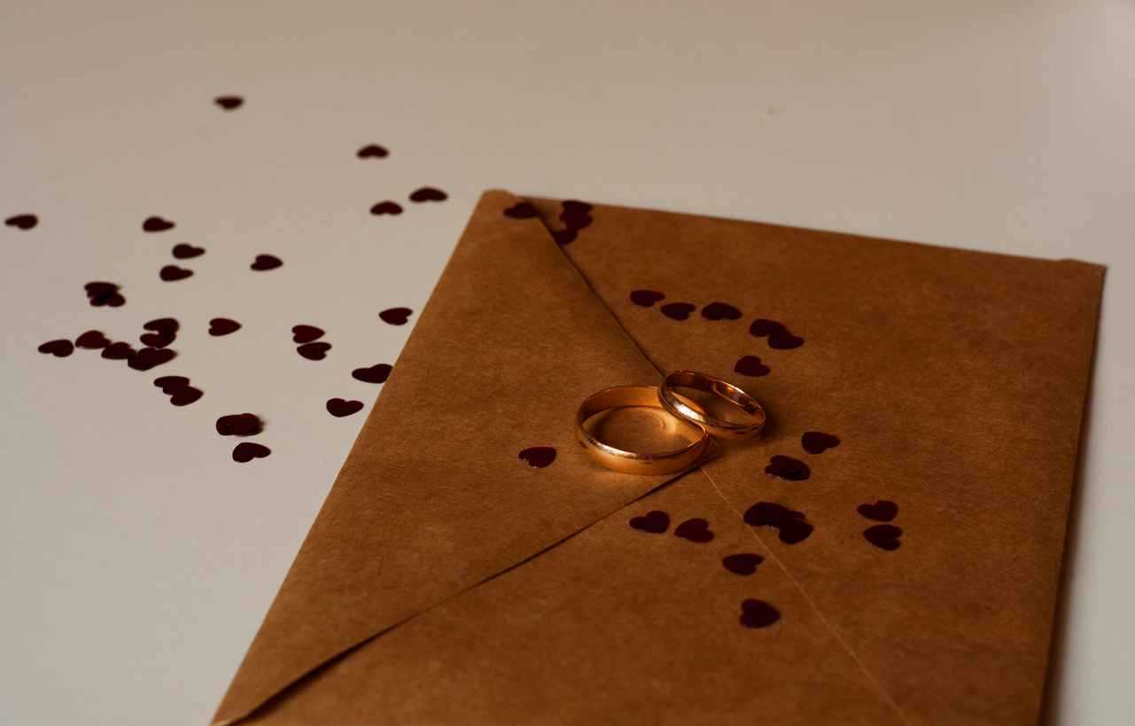 Retro wedding invitation and gold rings and heart confetti