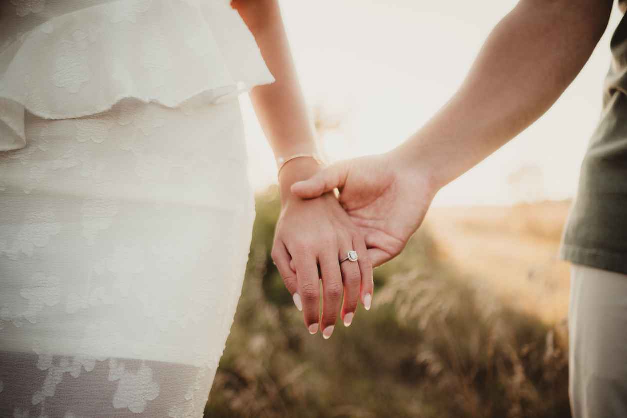 Engaged couple with focus on hands and engagement ring for wedding
